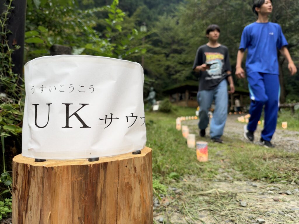 「UKサウナ」の看板と、会場を行き来するメンバー