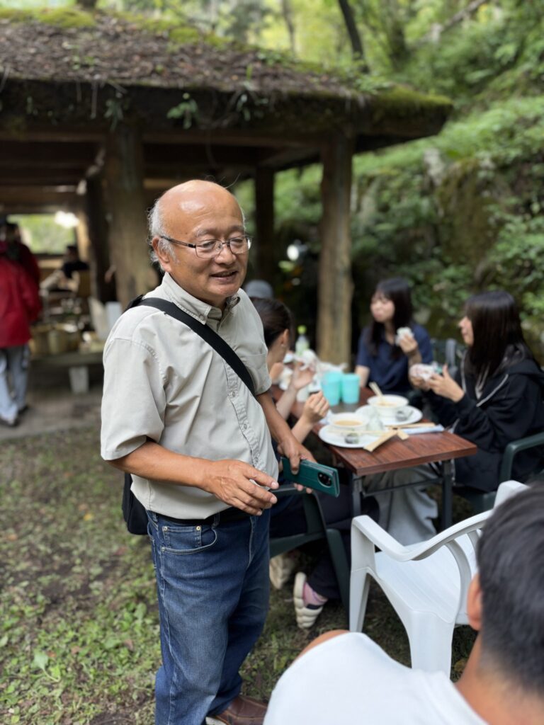 ふるまいの席で来場者と話す山崎理事